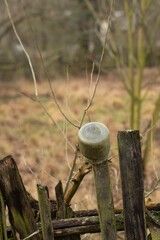 Wooden old rails, on one of them hung a jar, close-up, detail, blurred background.