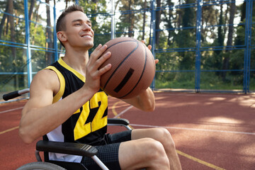 Handsome man with disability playing basketball in wheelchair