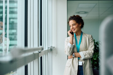 Happy businesswoman making phone call in office.