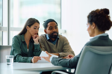 Young couple having consultations with financial advisor in office.