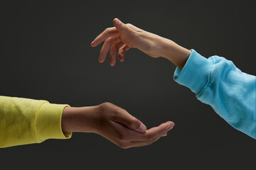 Diverse children's hands keeping safe, protecting something against dark grey background. Concept...