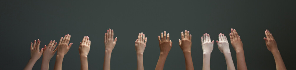 Many hands of diverse people, children raising their hands reaching up against gradient grey background. Concept of youth, expression, beauty, emotions, gestures, art and symbolism, diversity. Ad