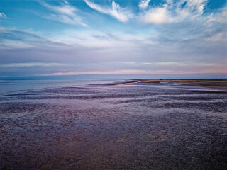 Coastal sunset scene. Aerial photograph showing tidal channels flowing through sand dunes. Lincolnshire Coast, Gibraltar Point. Summer evening sunset