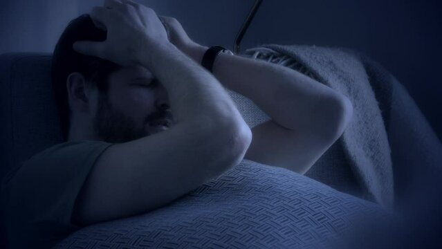 Man struggling with insomnia in moonlit room at night, close-up