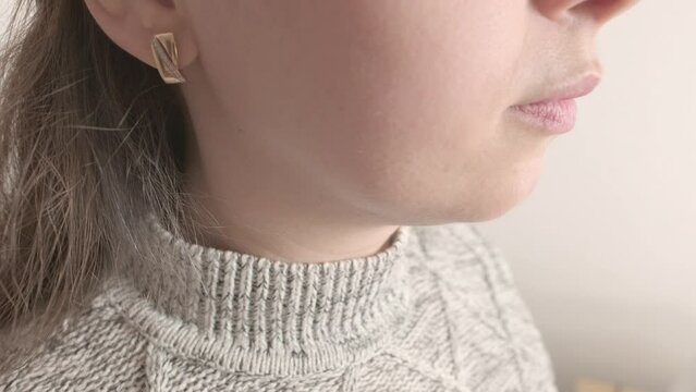 close-up young female neck, patient holding affected area, experiencing throat pain, Health concern, loss of voice, various causes, medical attention and treatment for condition, tonsillitis