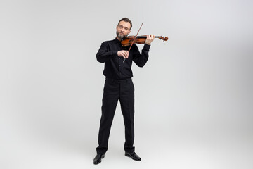 Bearded man violinist performing on concert