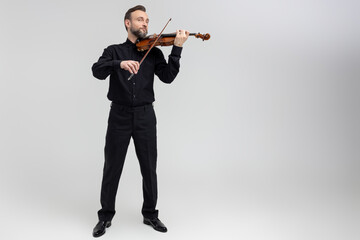 Adult man in black shirt playing violin