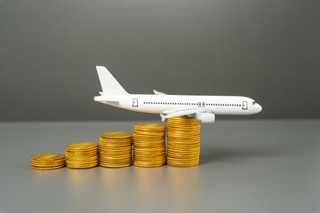 Saving on air travel. Loyalty programs and air miles, bonuses. Low cost airlines. Airplane on a growing stack of coins.