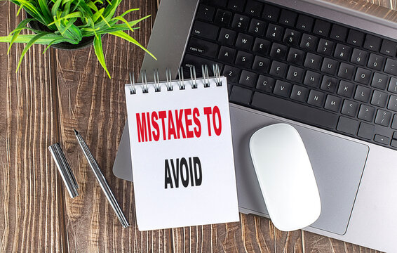 MISTAKES TO AVOID text on notebook with laptop, mouse and pen