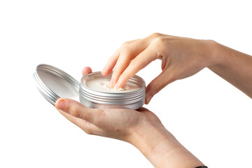 Female hand taking a sample of cream from a silver cosmetic tin against a white background, focusing on skincare and beauty