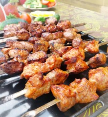 Pork kebab on skewers on a table outside the city.