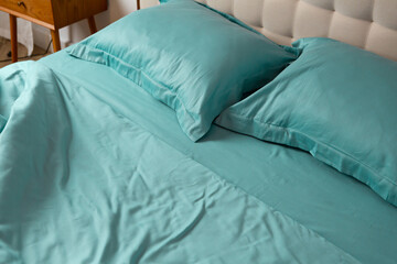 bright crumpled bed linen on an unmade bed