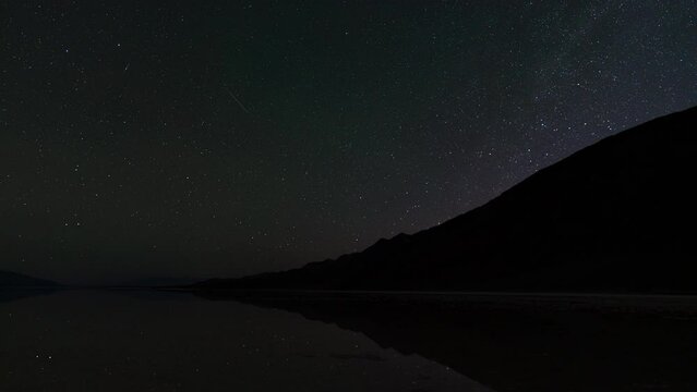 Timelapse night to day transition of north star reflected in ancient Lake Manly at Badwater Basin in Death Valley National Park in California, USA