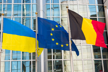 Fluttering flags of Ukraine, Belgium and the European Union in a row, close up