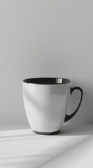 Obraz premium White cup with black rim sitting on a table. Vertical background 