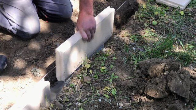 Setting edge restraints buy putting border curb stones in earth-moist concrete. High quality video