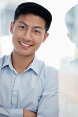 Asian business man, smile and arms crossed in portrait by window in modern office with confidence. entrepreneur, person and happy with reflection by glass, startup or creative media agency in Taiwan