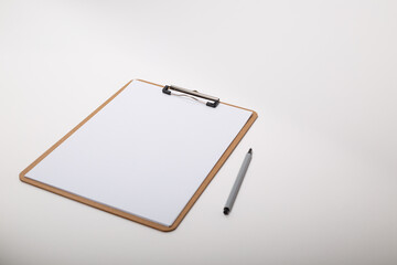 Wooden clipboard with blank white paper mock up with a pen
