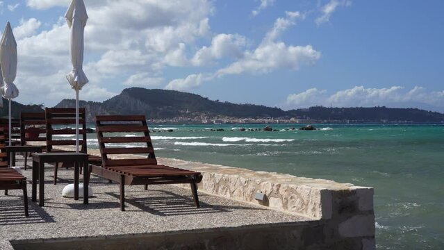 lounge chairs and sunshades on the shore and beach of ARgassi , Zakynthos