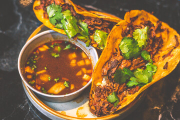 Beefy Birria Tacos made using 8 hour slow cooked chuck with beef consommé on the side