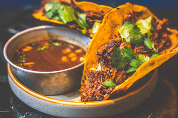 Beefy Birria Tacos made using 8 hour slow cooked chuck with beef consommé on the side