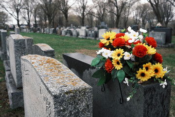 Bouquet coloré de fleurs sur une pierre tombale dans un cimetière