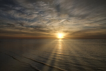 Sunset on the beach by the sea. Gentle waves. Sparkling water. The Baltic Sea