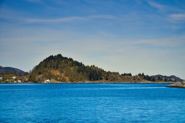 Fjord with mountains on horizon. Water glistens in the sun in Norway. Landscape