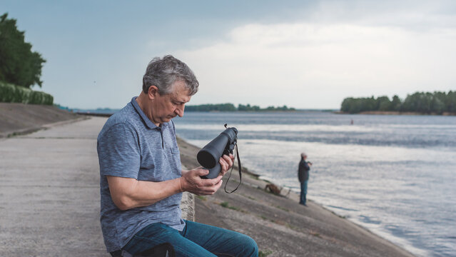 European Mature man looking in a binoculars . Hobby and recreation concept
