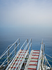 Sunlit gangway on a ship bow offers passage into uncertain terrains of the Mediterranean sea...