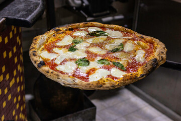 Tradizionale pizza margherita napoletana con sugo di pomodoro, mozzarella e basilico fresco appena...