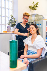 Happy hairdresser attending a beauty woman in the salon