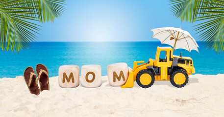Mom on wooden cube with yellow truck and jute sandles on tropical beach, mother's day card background idea
