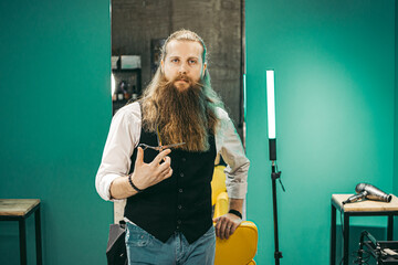 Man Bearded barber portrait .Male european young barber barber cheerful bearded long haired,...