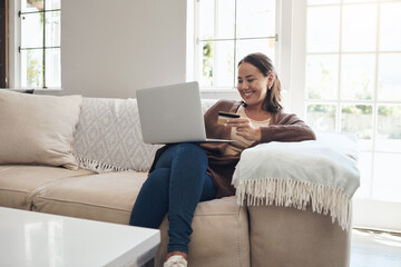 Woman, laptop and credit card on couch to pay, finance and website for online shopping in home....