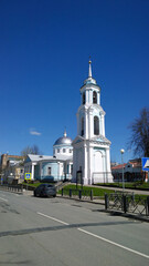 Bell tower and Church of the Assumption of Blessed Virgin Mary. Ancient historical architecture. City street. Clear blue sky. Travel destination. Russian travelling. Pskov, Russia 