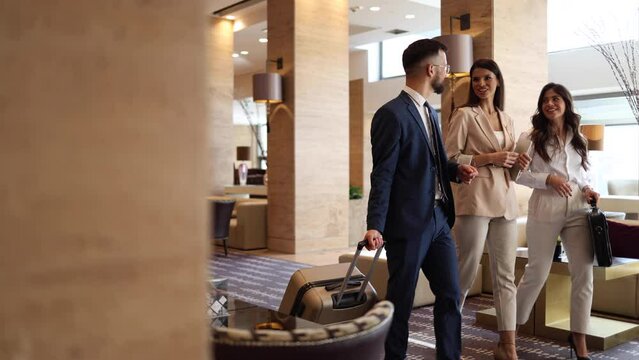 Young businessman and his female colleague arriving at the hotel on a business conference