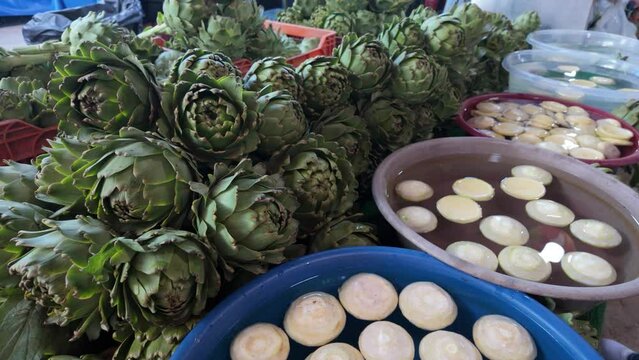  video of vegetables stand with fresh artichokes at the farmers market place in Urla Turkey. Regional cuisine, natural healthy food and abundance concept. High quality 4k footage