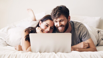 Embrace, couple and relaxing with laptop on bed for bonding by watching movie, film and comedy...
