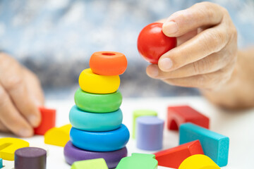 Alzheimer disease AD, Asian elderly woman patient suffering from dementia learn practical motor skills rehabilitation.