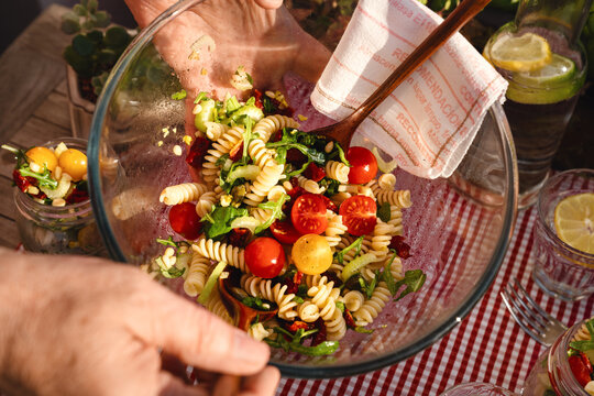 Veganer Italienischer Nudelsalat drau&szlig;en auf dem Tisch rot weis karierte Tischdecke