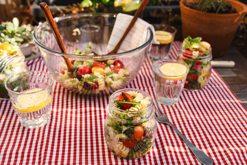 Veganer Italienischer Nudelsalat draußen auf dem Tisch rot weis karierte Tischdecke