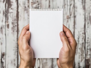 hand holding white notepad