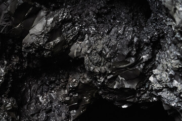 Wet basalitic rock texture. Pattern, geometry, geology, light reflections. Structure of rocks inside a cave. Icelandic black beach.