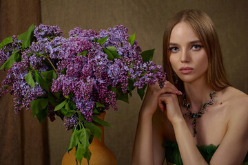 portrait of a beautiful young girl with exquisite makeup with a bouquet of lilacs