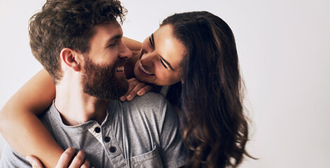 Couple, smile and hug by white background for love, romance and partnership in studio with pride....