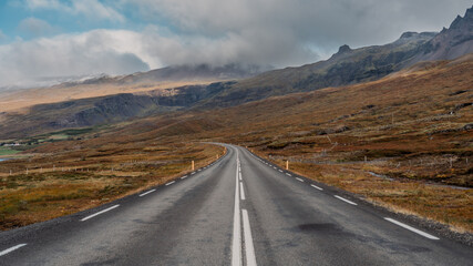 Long asphalt road runs through Iceland. Travelling, exploring, breathtaking views, volcanic landscapes.