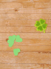 A wooden table with a green shamrock and four hearts on it
