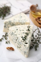 Tasty blue cheese with thyme on white table