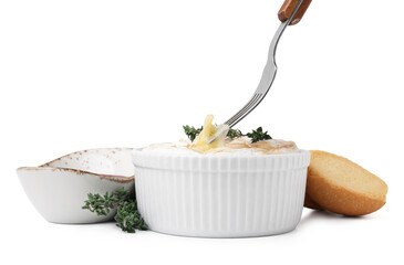 Eating tasty baked camembert with fork from bowl on white background, closeup